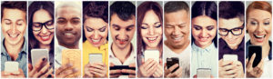 Cut of 10 diverse people all looking at their phones while smiling