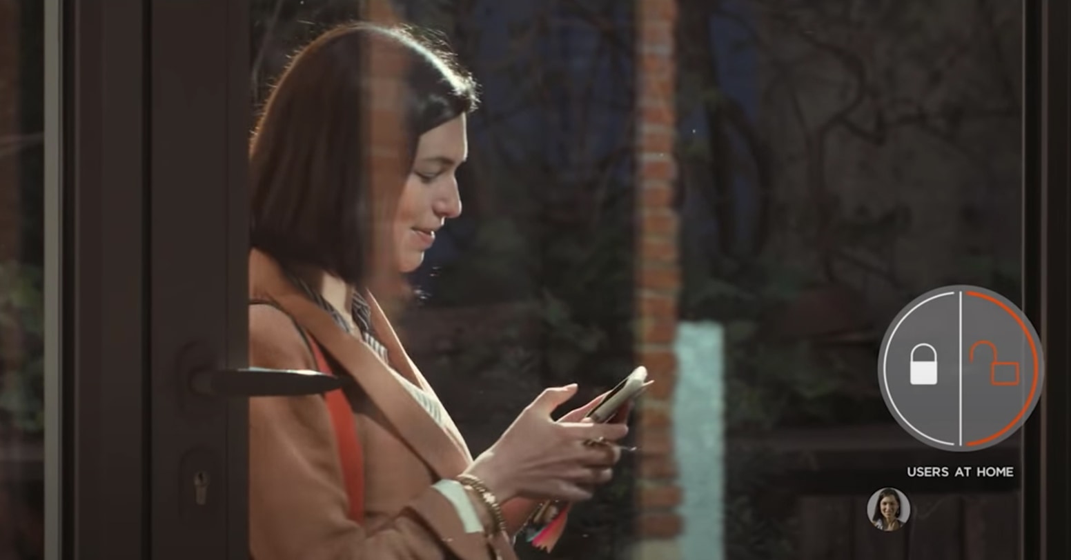 still from a youtube video showing a woman looking at her smartphone with a graphic overlay of a lock