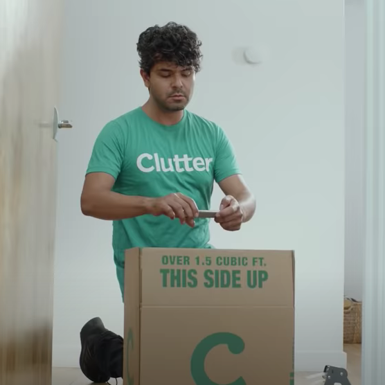 Clutter employee taking a photo of a moving box's contents for categorization