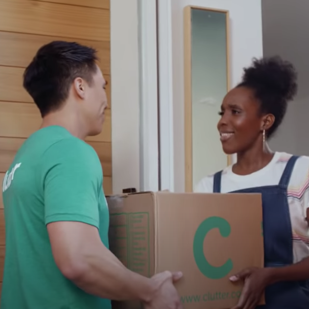 Clutter employee handing a box of personal items to a woman at her house
